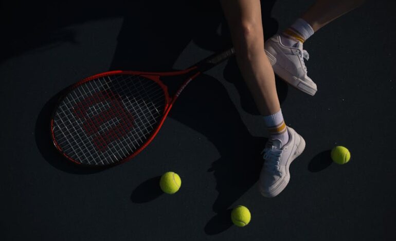 A close-up shot of a tennis player on a court with a racket and tennis balls.