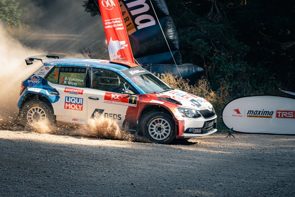 Skoda Fabia R5 racing on a dusty track during a vibrant motorsport rally event.