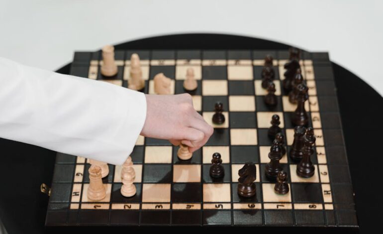 Close-up of a hand strategically moving a chess piece on a wooden chessboard.