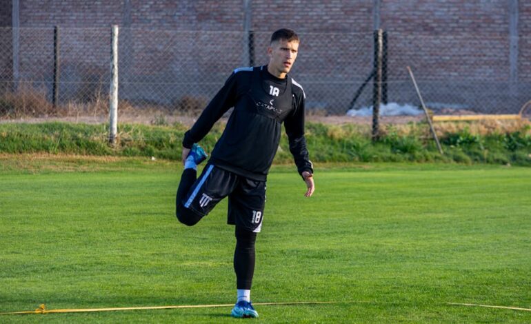 A football player stretching outdoors on the field during training for improved performance.