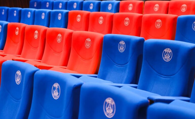 Rows of red and blue stadium seats featuring Paris emblems, vibrant and empty.