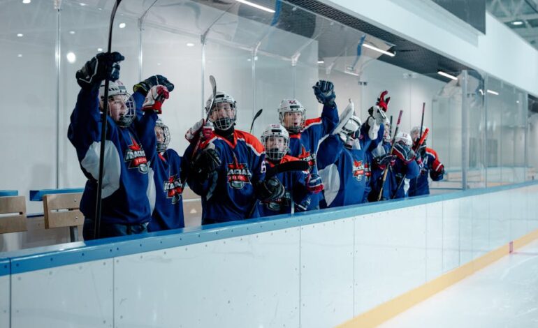 Youth hockey players celebrating in the ice arena, showing team spirit and unity.