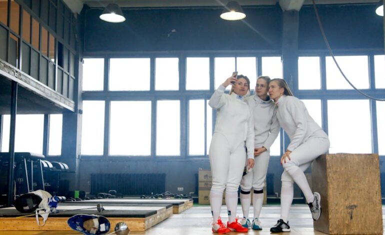 Three female fencers capture a selfie in a gym, showcasing camaraderie and athletic spirit.