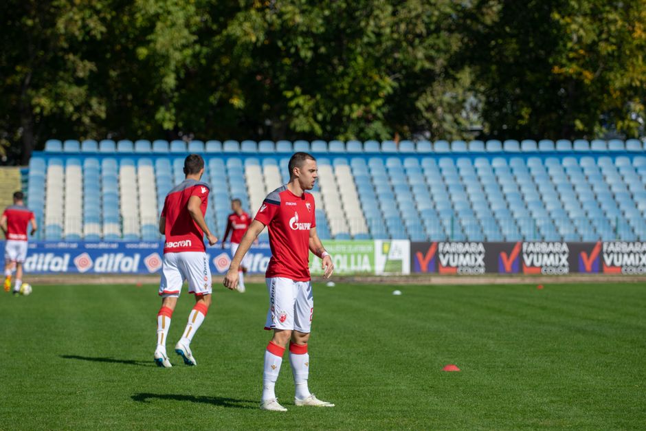 Athletes practicing soccer on an outdoor field in team uniforms.