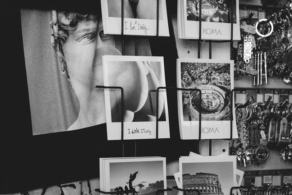 A black and white photo showcasing a display of Italian-themed postcards featuring Rome and famous sculptures.