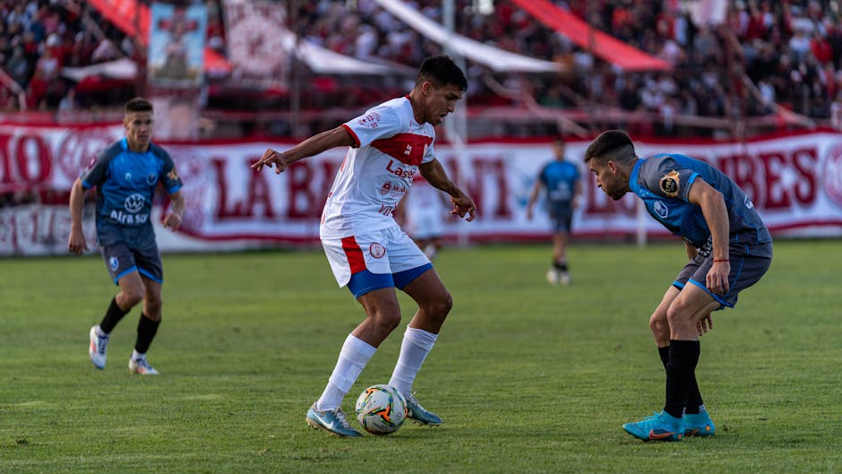 Football players in action during a competitive match on the field.