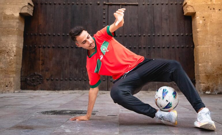 A young man skillfully performs a soccer trick with a ball, showcasing talent and athleticism in a vibrant urban setting.
