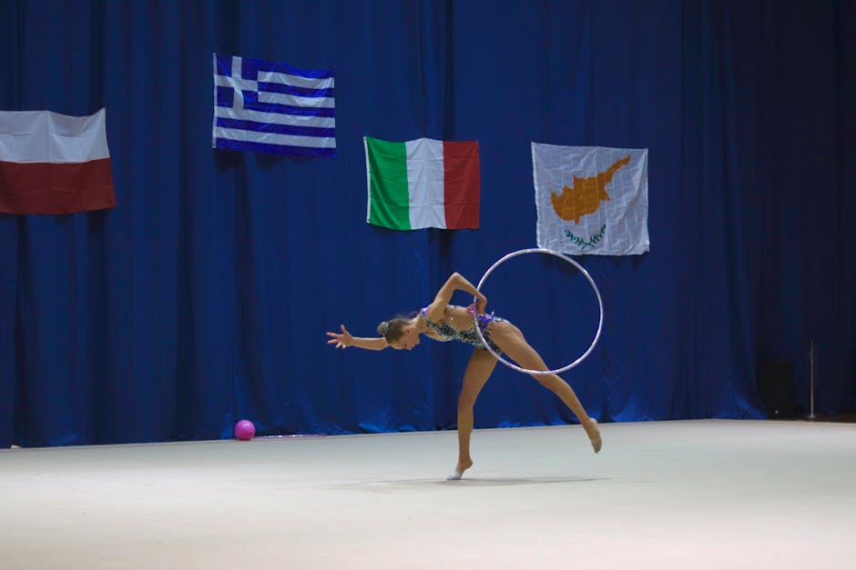 Dynamic image of a gymnast performing with a hoop on an international stage.