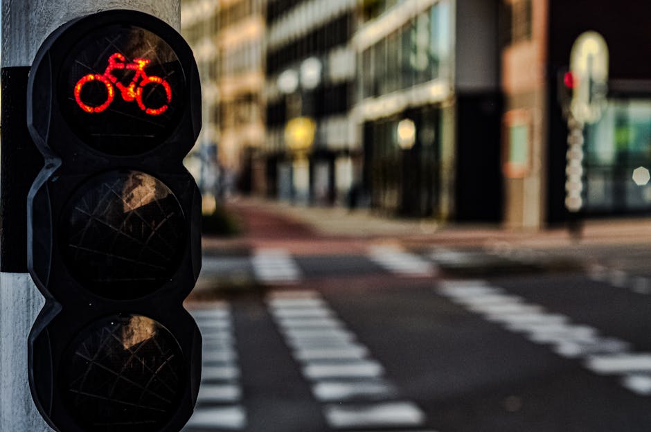 Red bicycle traffic light with blurred city background in Amsterdam, Netherlands.
