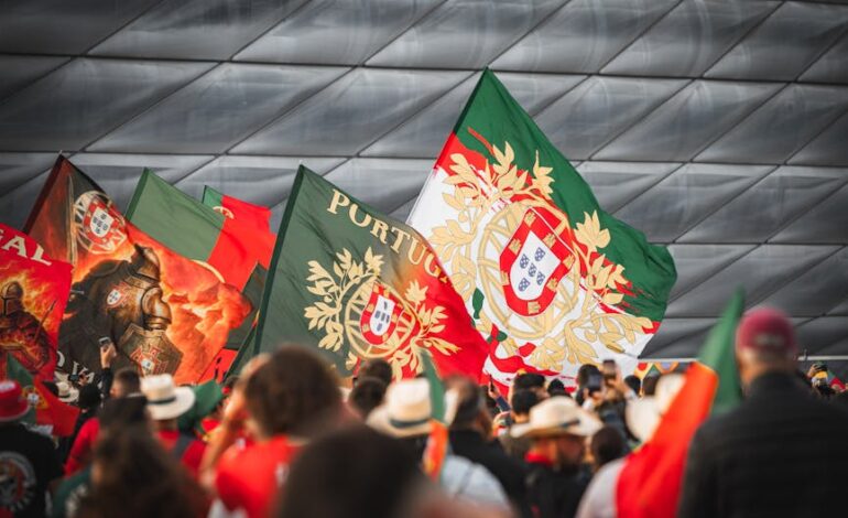 Crowd of Portuguese fans waving flags at Allianz Arena in Munich during a football event.