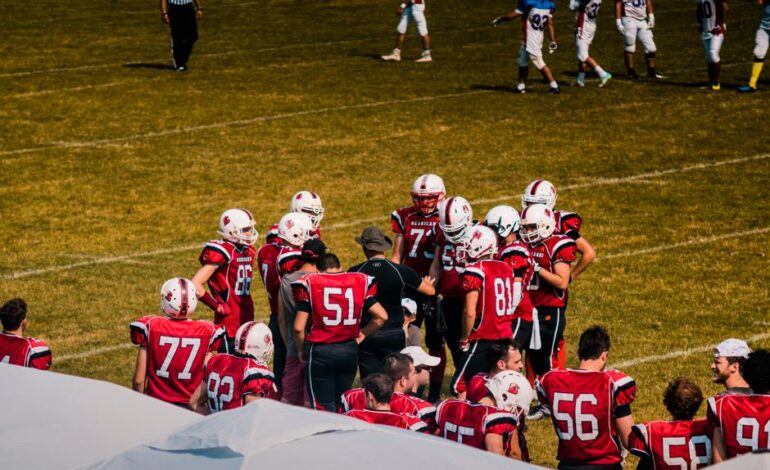 American football team huddling on field for strategy meeting during a game.