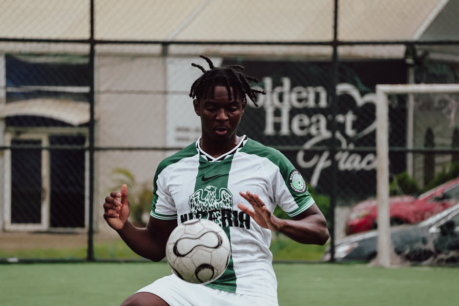 Young male soccer player on an outdoor field skillfully controlling the ball.