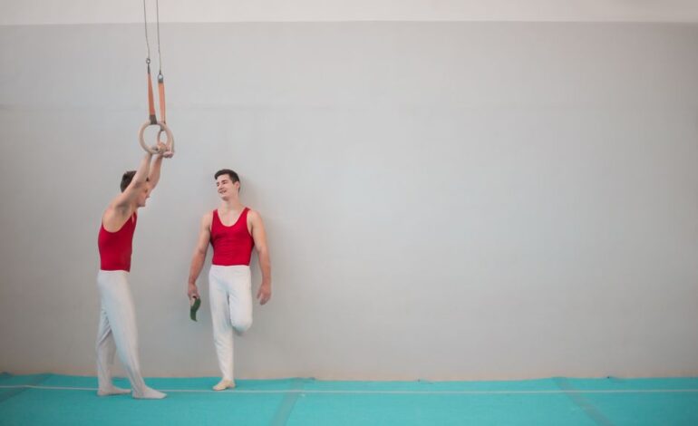 Powerful black haired gymnasts in sportswear talking while standing on sport room with professional equipment