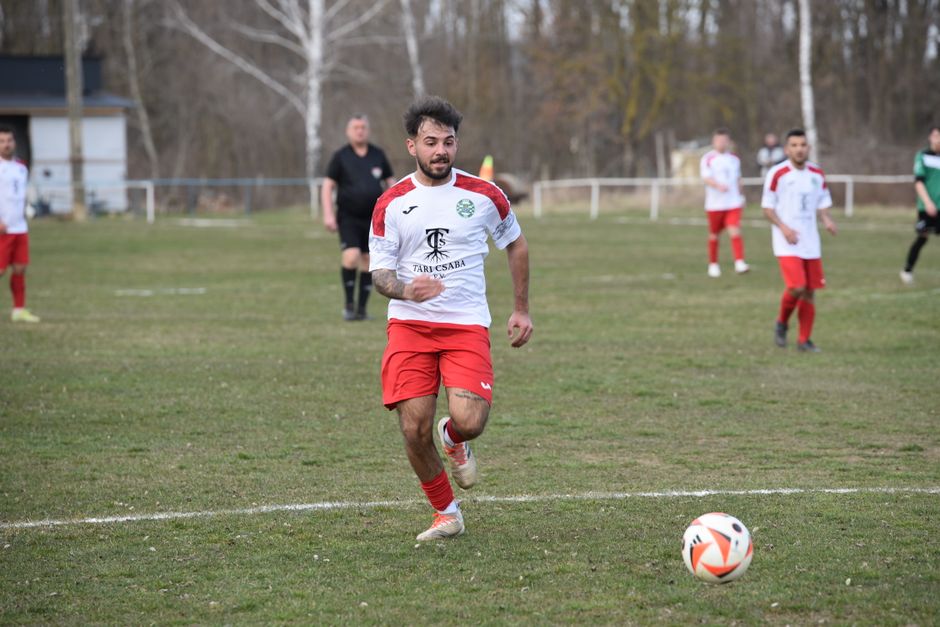 Soccer player running with focus during a competitive outdoor match.