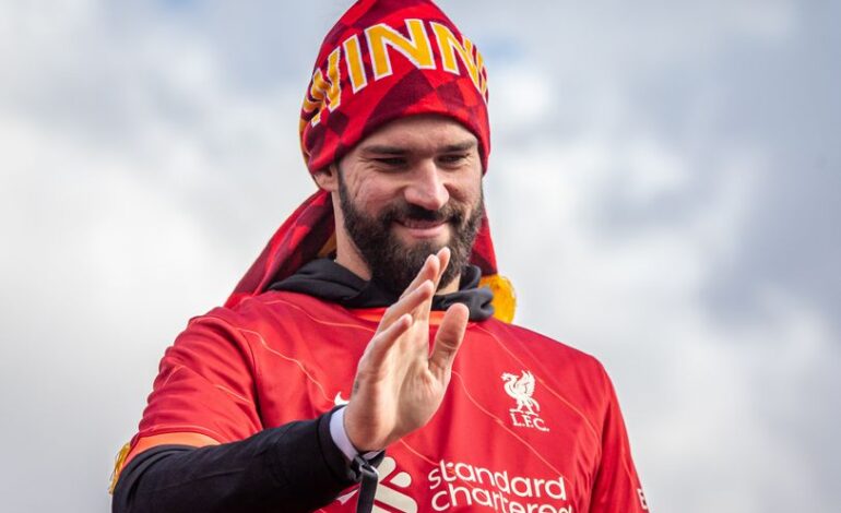 Liverpool FC player joyfully celebrates victory under the clear sky.