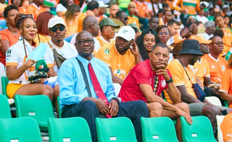 Cheerful crowd of diverse football fans enjoying a live match in a vibrant stadium.