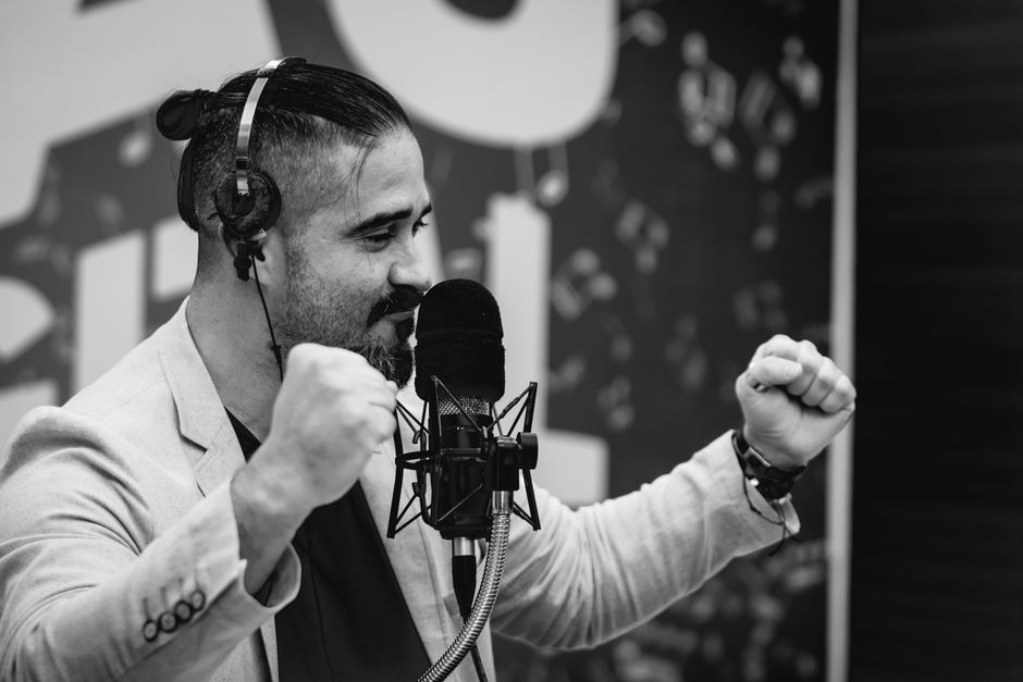 Dynamic black and white shot of a man speaking passionately into a microphone.