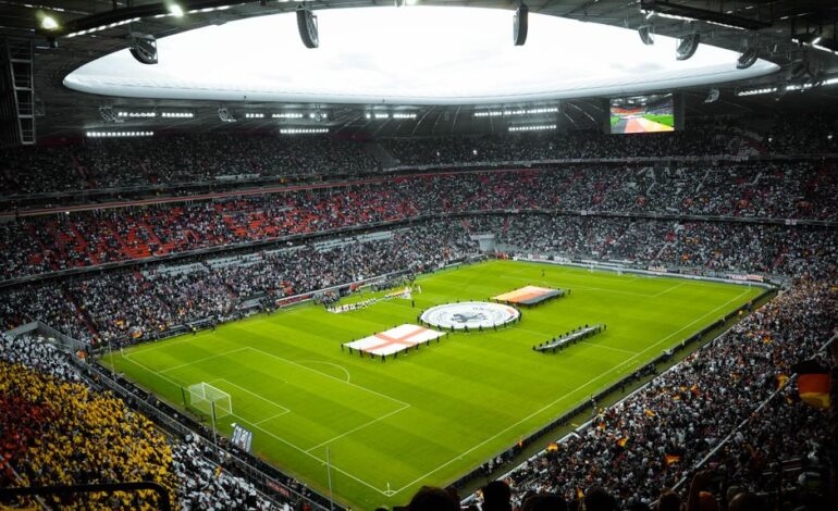 A vibrant soccer stadium filled with fans watching a game, flags displayed on the field.