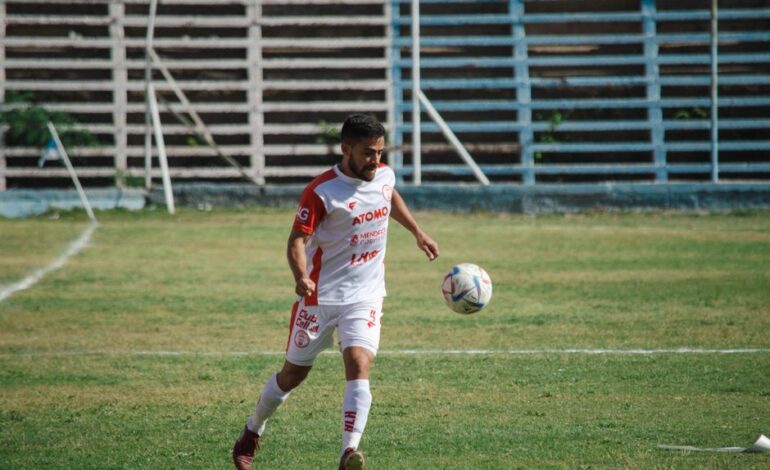 Soccer player in white kit playing on a field in Mendoza, Argentina.