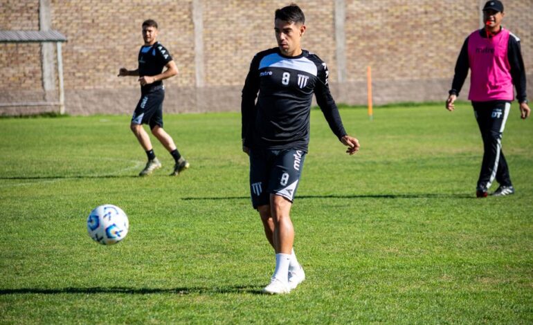 Focused football player in training session on green field under daylight.