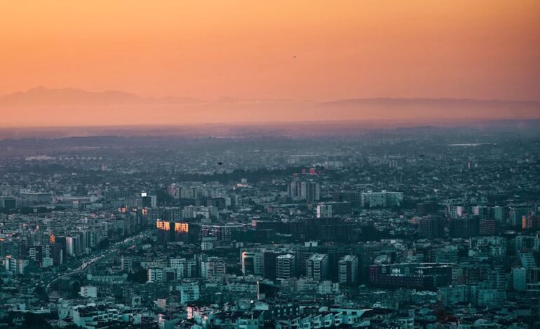 A stunning aerial shot of Tirana, Albania with vibrant orange skies during sunset. Perfect for travel and cityscape enthusiasts.