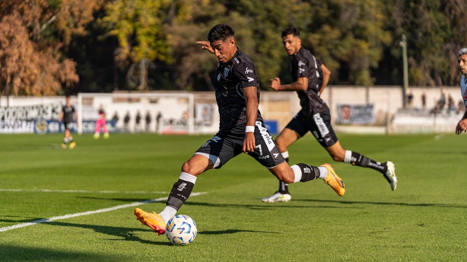 Dynamic action shot of footballers on the field during an outdoor game, showcasing sportsmanship and movement.