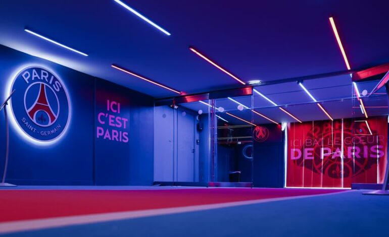 Spacious PSG entrance hallway in Paris with striking neon lighting and club branding.