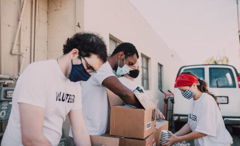 Volunteers packing food donations outdoors to support a local charity event.
