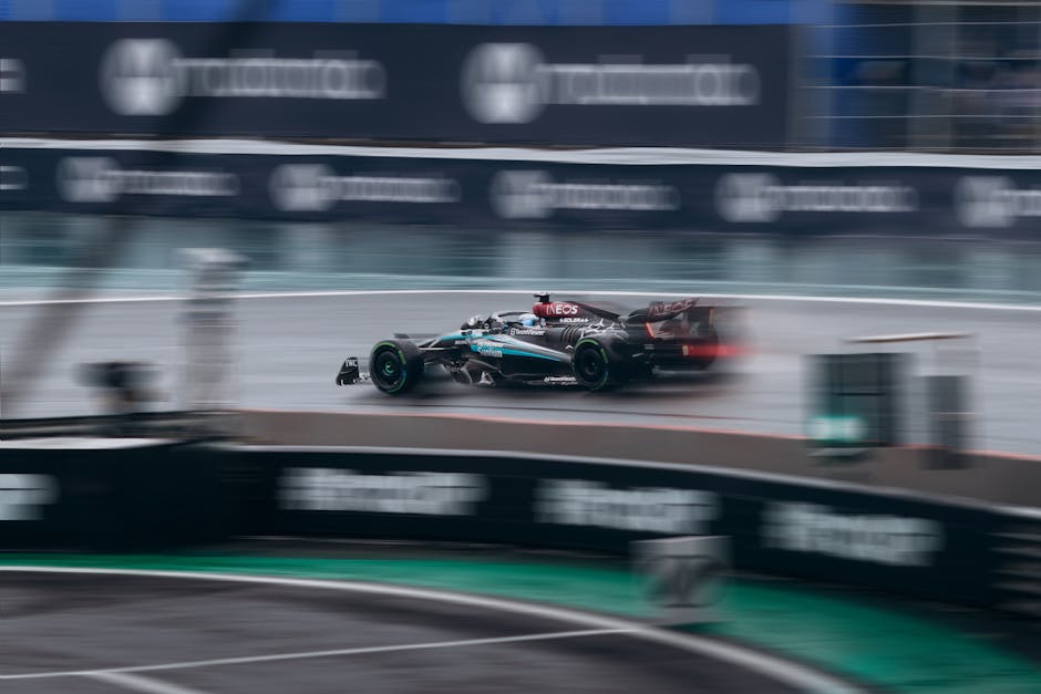 Dynamic shot of a racing car speeding during a Formula 1 event on a wet track.