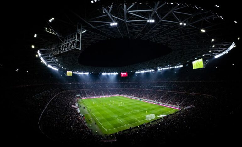 Aerial view of a night football match in Budapest. Illuminated stadium full of fans adds dramatic atmosphere.