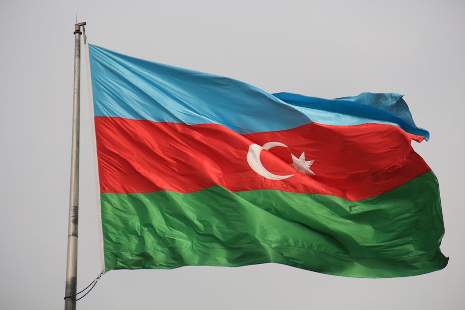 Azerbaijan national flag waving against a clear sky, showcasing vibrant colors.