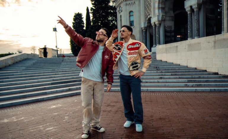Casual moment captured of two friends in stylish jackets exploring historical architecture on a sunny day.