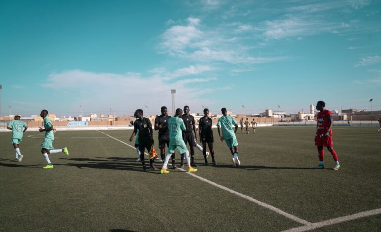 A group of male soccer players on a field during a sunny day game.