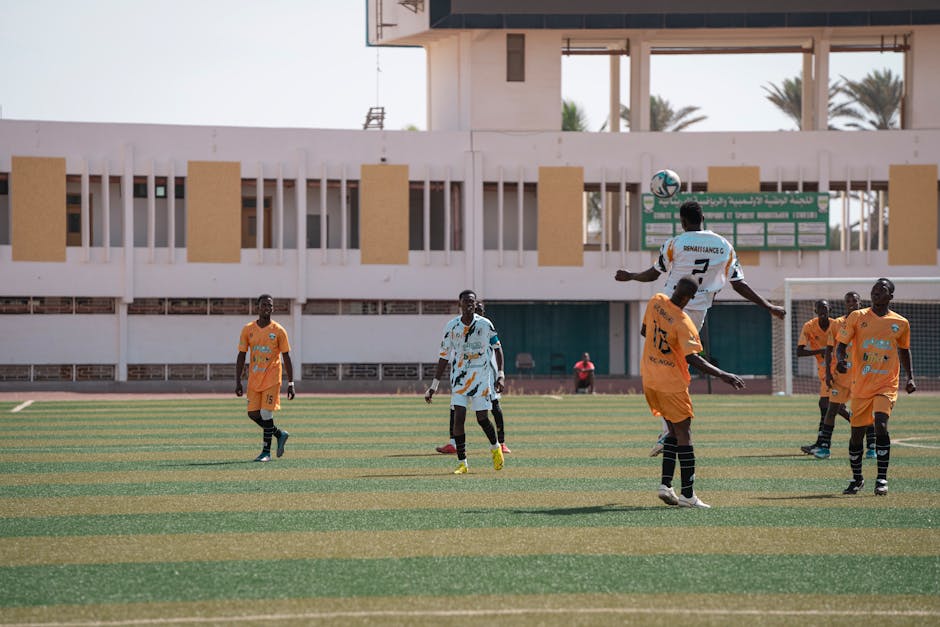 Dynamic soccer match outdoors with athletes on a sunny day.