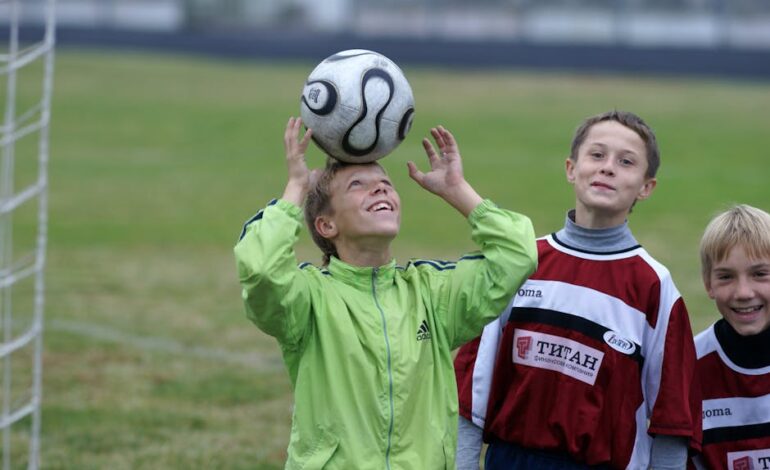 Three young soccer players practicing headers on a soccer field, enjoying their game outdoors.