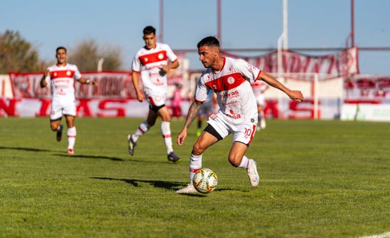 Players engaged in a competitive soccer match outdoors on a sunny day.