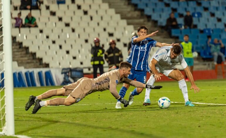 Dramatic soccer scene with goalkeeper diving to stop two players in a competitive match.