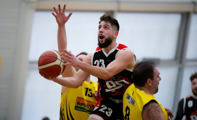 Dynamic indoor basketball action with players vying for the ball and scoring opportunity.
