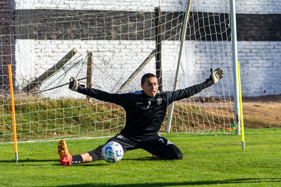 Goalkeeper skillfully defending the goal during a sunny outdoor soccer training session.