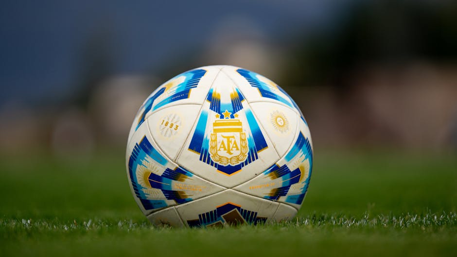 Detailed view of a soccer ball with AFA logo on a green field.