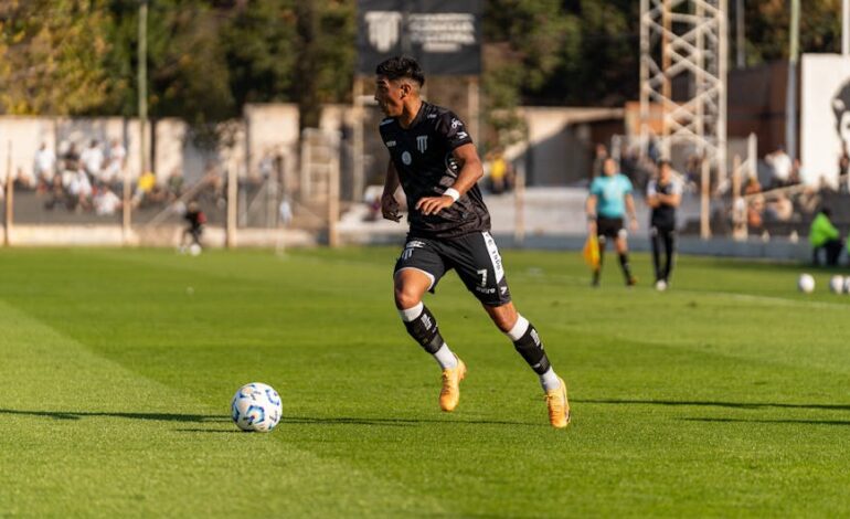 Soccer player dribbling the ball during a daytime match outdoors.