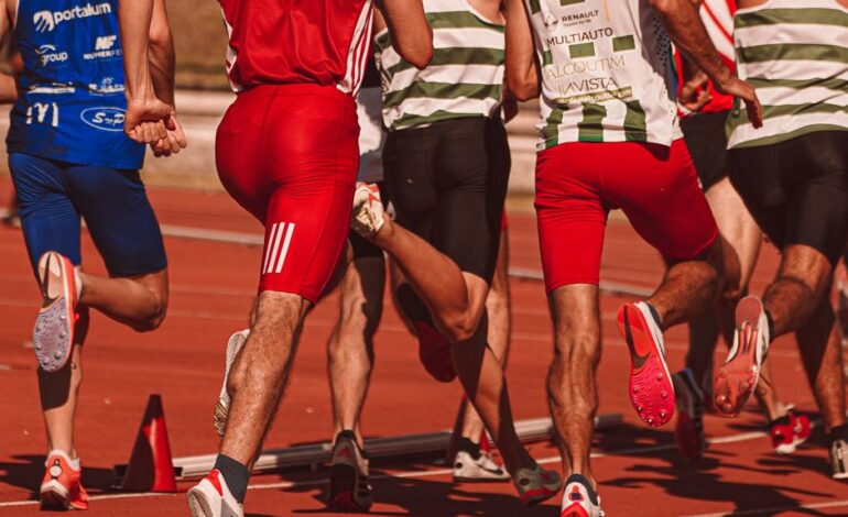 Dynamic view of male athletes running in a competitive track race outdoors.