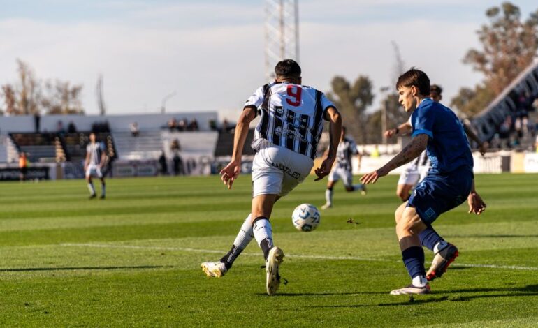 Players in action on the soccer field during an outdoor match under the bright sun.