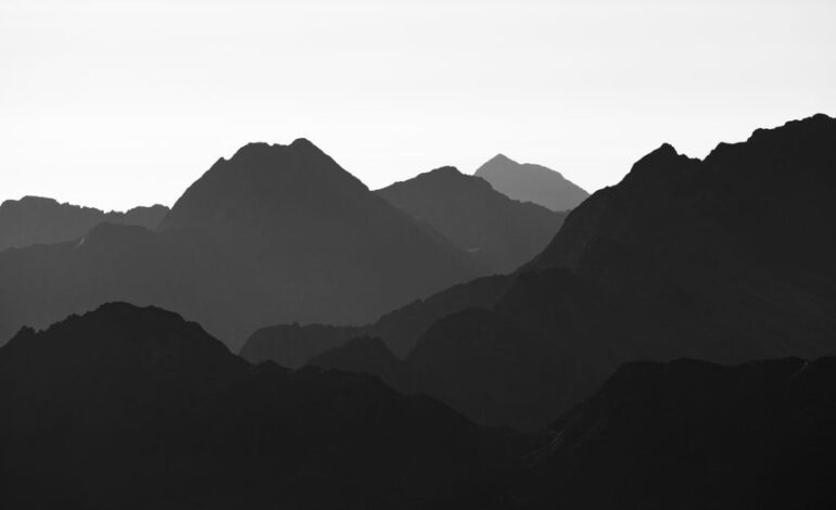 Silhouetted mountains in black and white, capturing the serene beauty of nature.