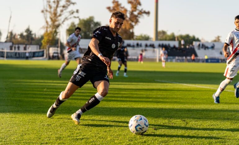 Dynamic action shot of a football match, capturing players in motion during a sunset game.