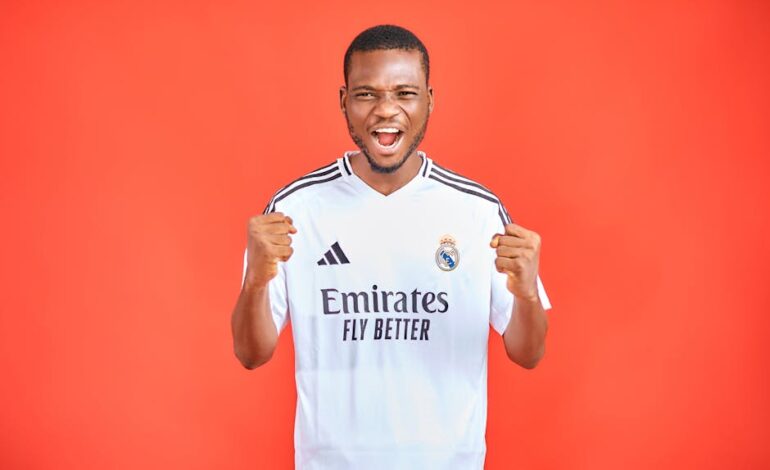 Energetic soccer fan in a team jersey cheering against a vibrant red background.