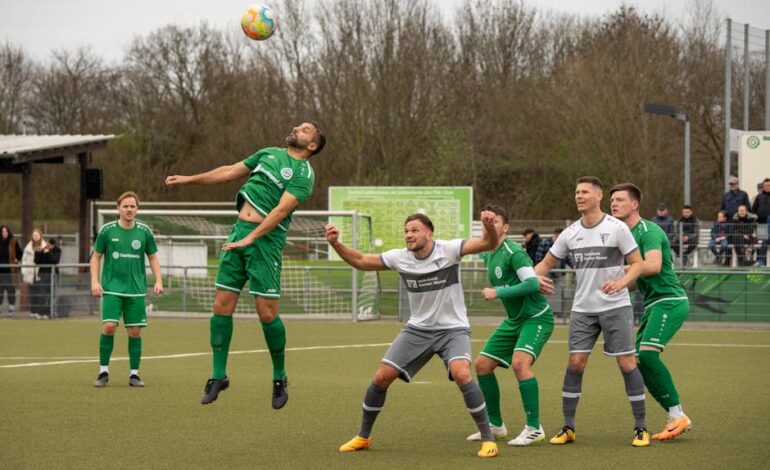 Dynamic action shot of adult men playing soccer outdoors, illustrating teamwork and athleticism.